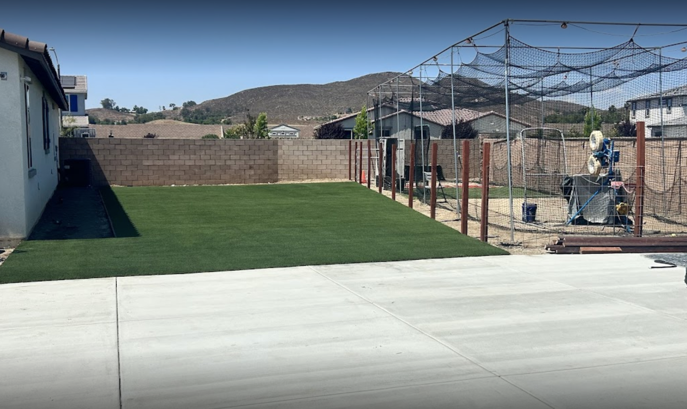 Backyard synthetic turf next to batting cage